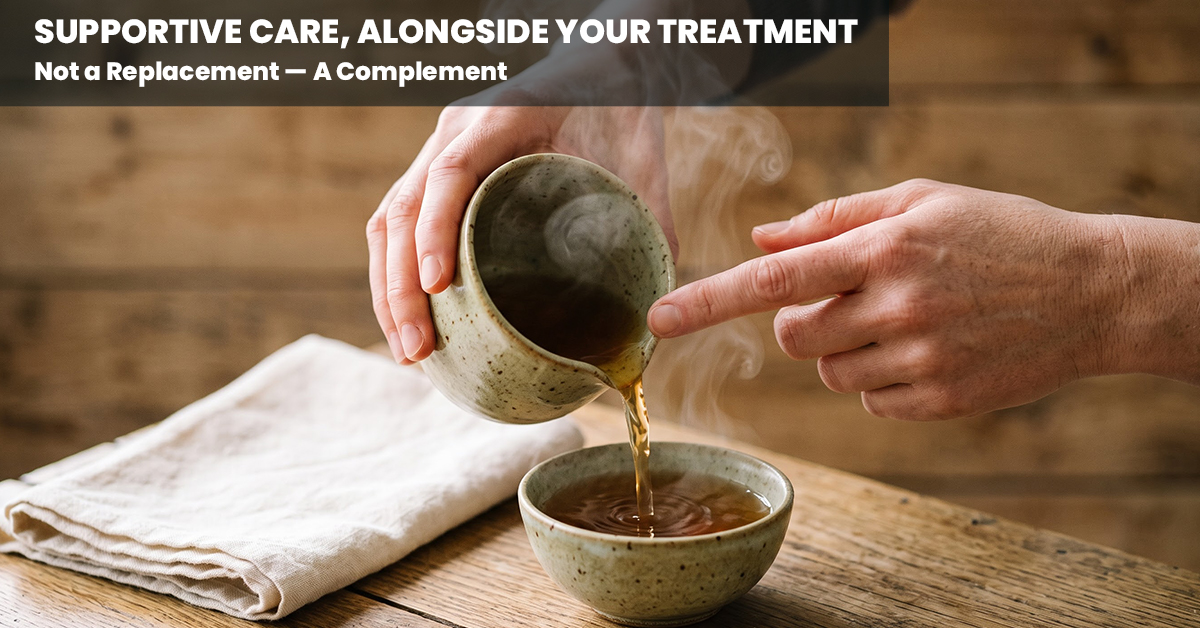 Hands pouring a warm herbal supportive-care drink, representing Ayurvedic care alongside cancer treatment